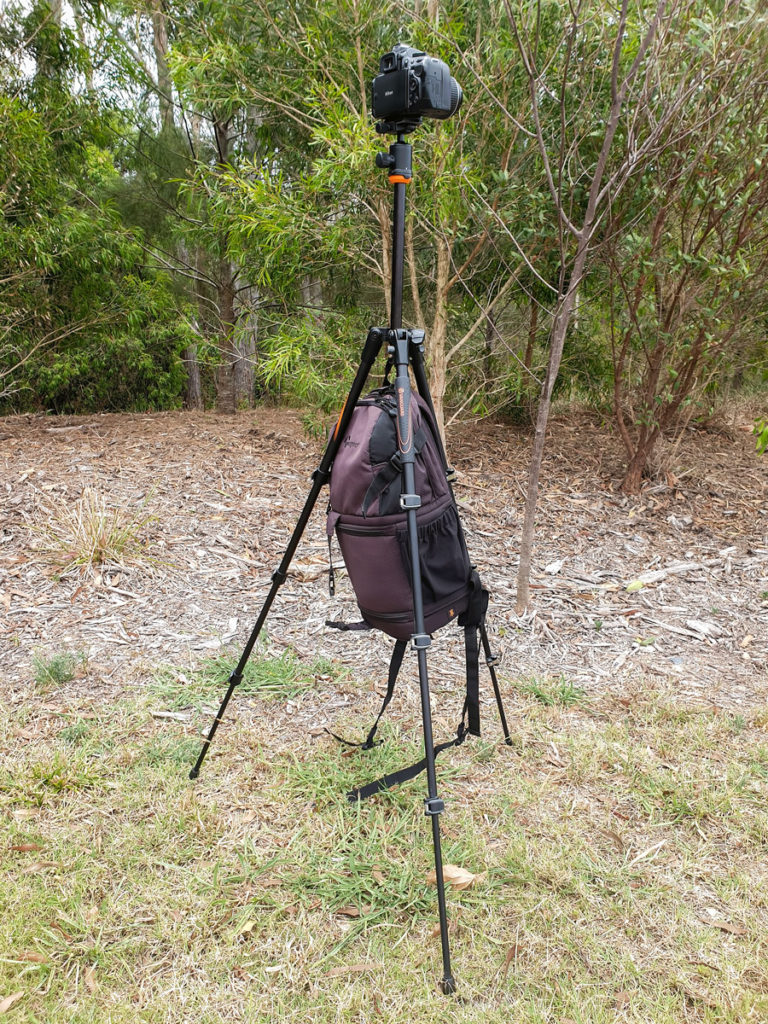 5 landscape photography tips - a camera on a tripod with a bag hanging underneath the tripod