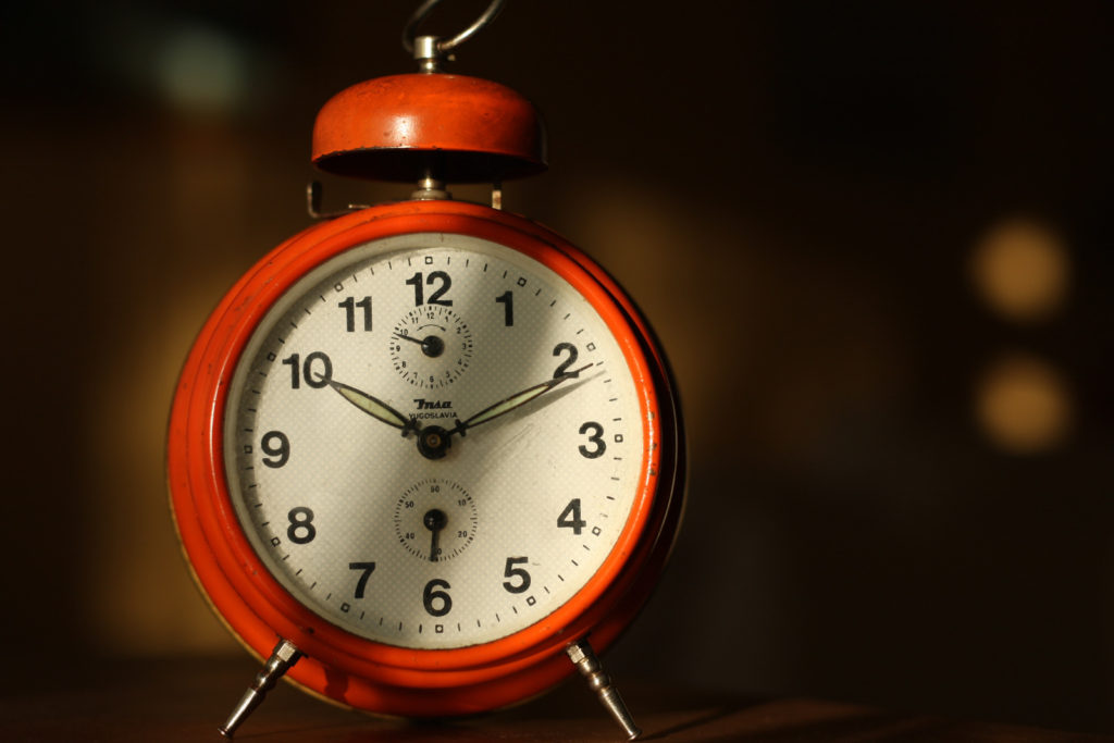 old style orange alarm clock signifying the time photographer's freedom can give you