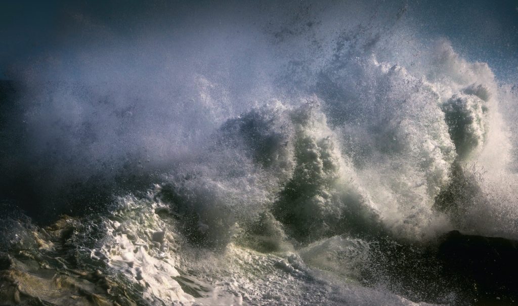 how to follow your passion - a huge wave crashing against rocks